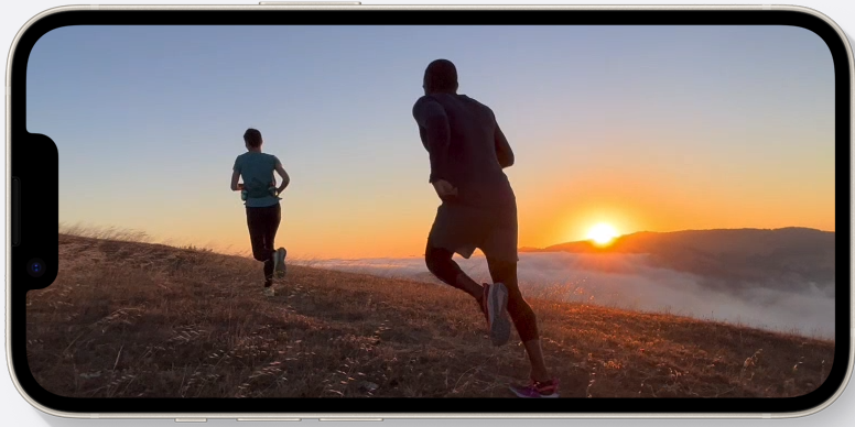 Een iPhone waarop gefilmd wordt hoe twee mensen aan het hardlopen zijn door de bergen tijdens een zonsondergang